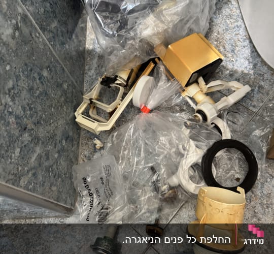 חלקי אינסטלציה וכלים על רצפת חדר אמבטיה